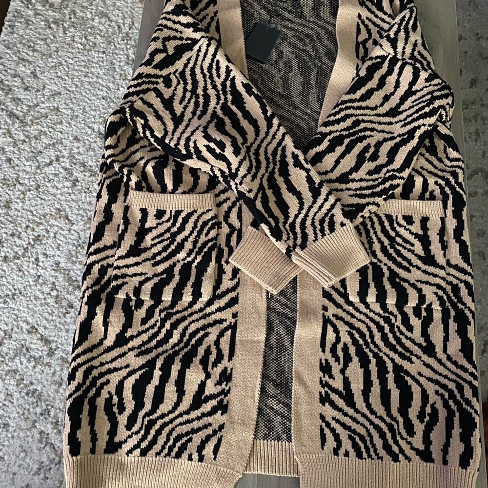Zebra print long sleeve cardigan. The bottom hits knees.